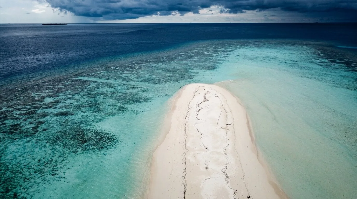 Aerial view of North Malé Atoll, Maldives — The natural opening chapter of an Atoll Villa journey — coral gardens, sandbanks and surf within an easy first afternoon of the airport.