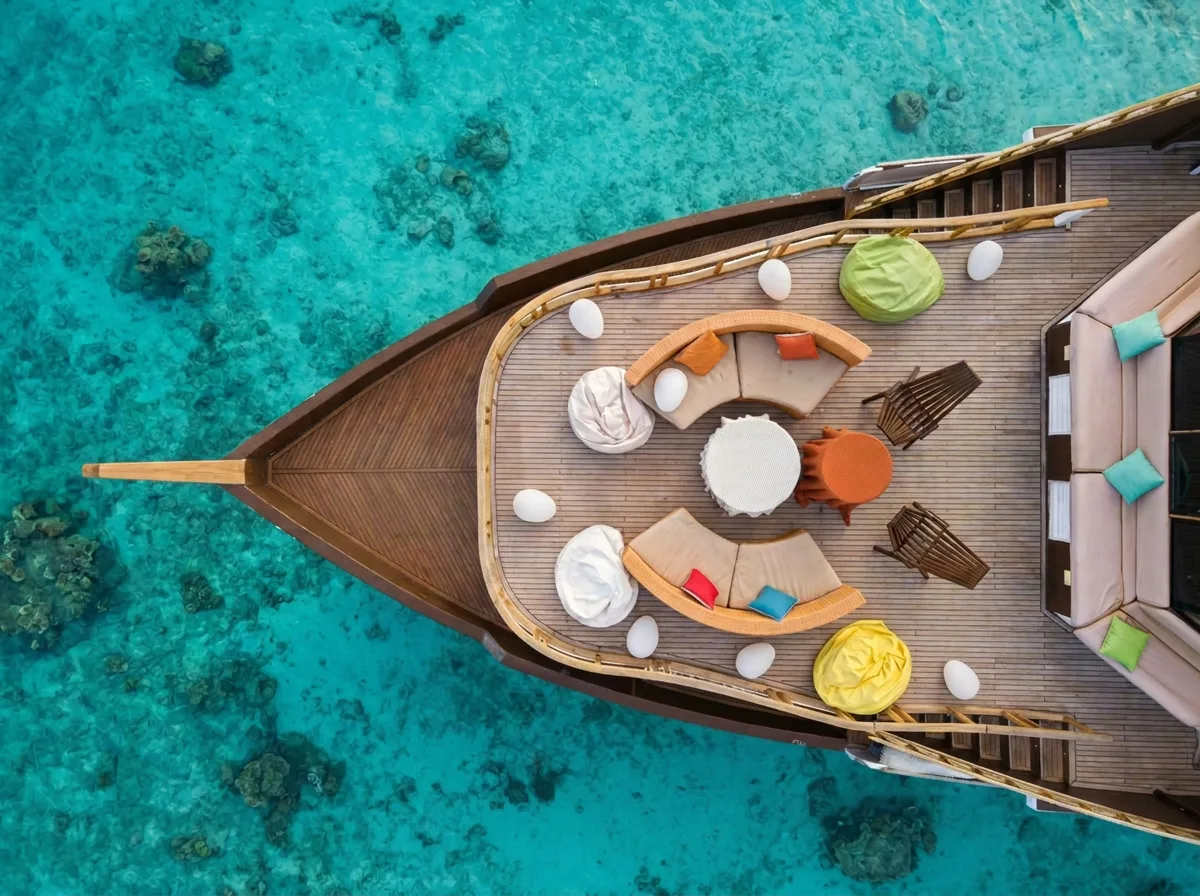 Atoll Villa anchored alone in a turquoise Maldivian lagoon at golden hour