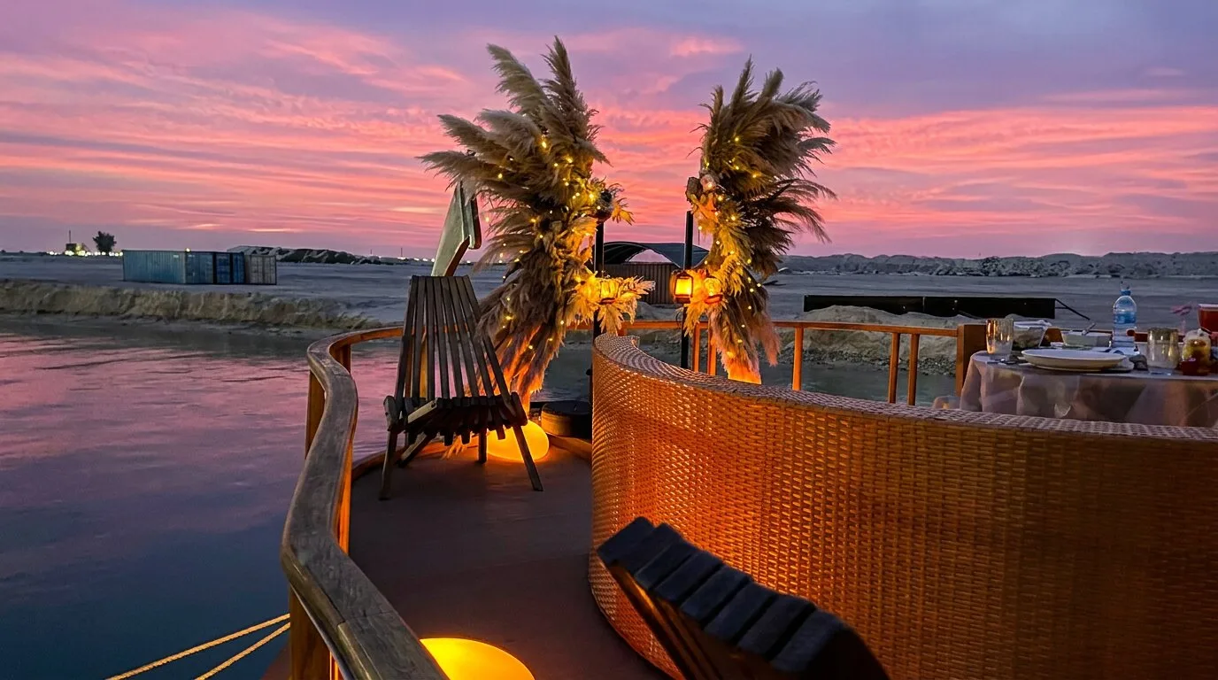 Sunset Yacht Dining Maldives | Romantic Private Dinner Cruise | Atoll Villa Elegant sunset dining setup aboard Atoll Villa with a beautifully decorated table overlooking the Indian Ocean as the sun sets over the Maldives.