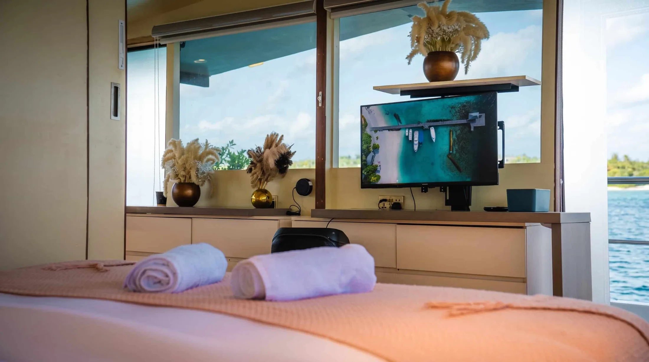 Luxury Master Suite on a Private Yacht | Atoll Villa Maldives Spacious master suite aboard Atoll Villa featuring a king-size bed, panoramic ocean-view windows, elegant Maldivian-inspired interiors, private ensuite bathroom, smart controls, and luxury amenities.